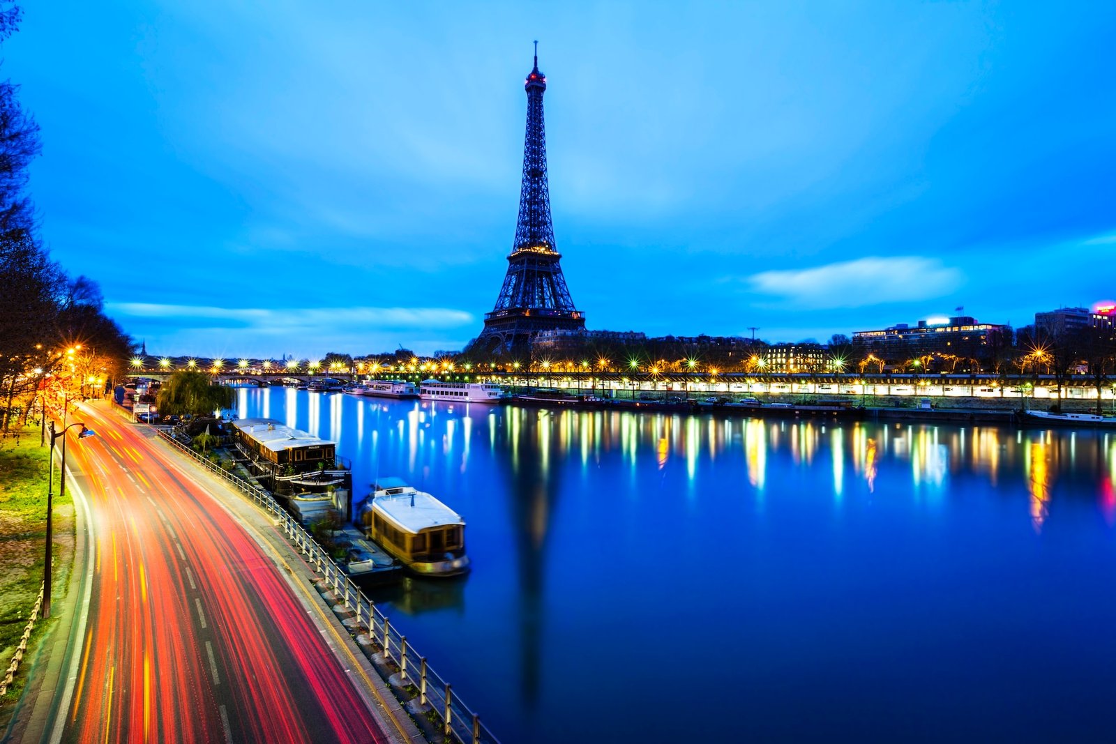 Fotografía de larga exposición de una concurrida calle parisina con la torre Eiffel durante la hora azul